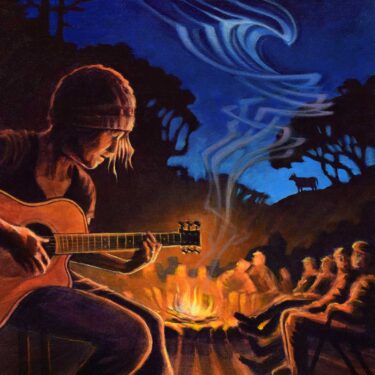 My wife rocking out on guitar by a campfire on a cattle ranch